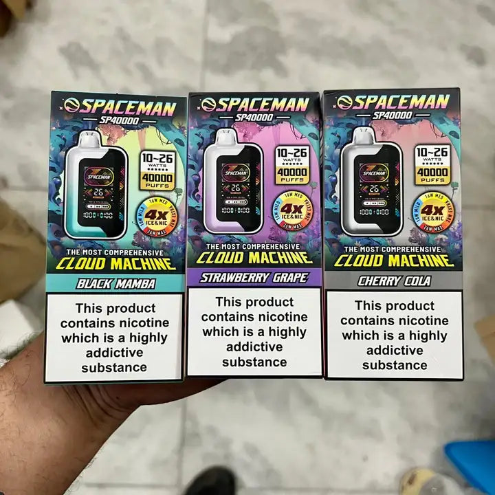 Three Spaceman vape device packaging with different flavors i hand.