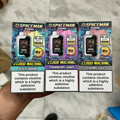 Three Spaceman vape device packaging with different flavors i hand.